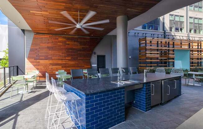 a patio with a bar and chairs and a building in the background at The Chase at Bryant Street, Washington