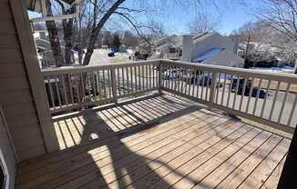 A wooden deck with a shadow of a tree on it.