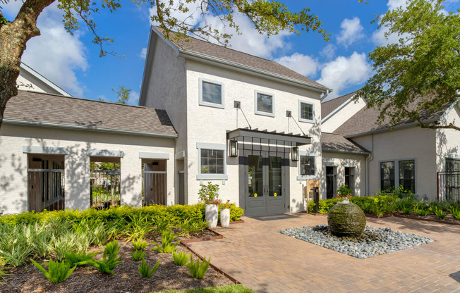 the front of a house with a brick walkway and a fountain at Summerwind, Pearland, TX