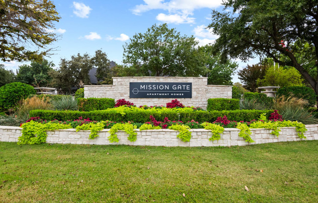 Welcoming Gate surrounded by grass and well manicured landscaping at Mission Gate in Plano TX