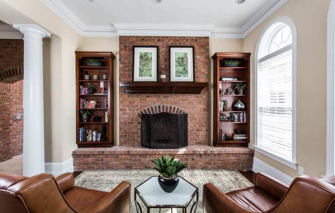 a living room with a brick fireplace and leather furniture