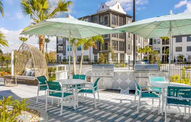 A patio with white furniture and green umbrellas.