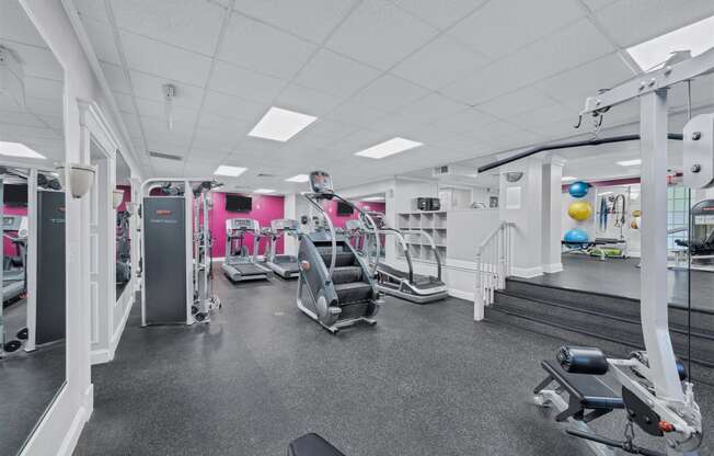 a gym with cardio equipment and weights on the floor of a building