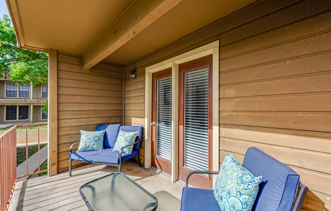 a covered porch with chairs and a table