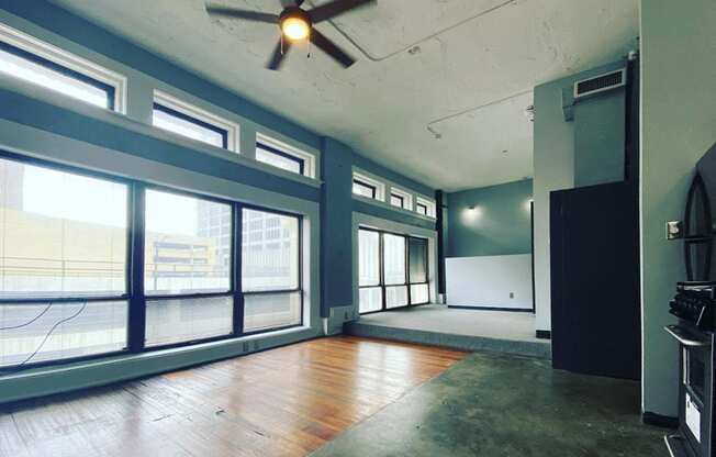 large windows in loft with ceiling fan and hardwood and concrete floors at Jemison Flats, Birmingham, AL, 35203