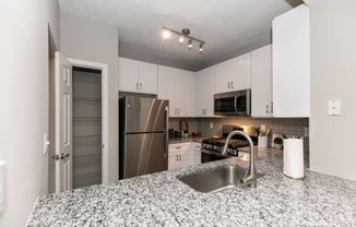 a kitchen with granite counter tops and a stainless steel refrigerator at Willowest in Collier Hills, Atlanta, 30318