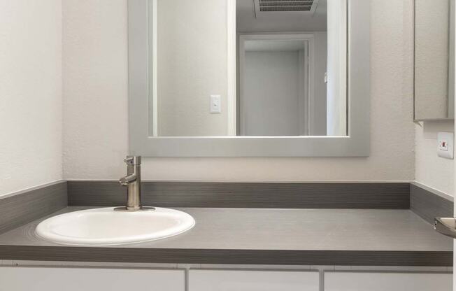 A bathroom with a sink and a mirror.