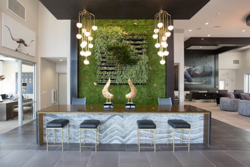 a kitchen with a counter and stools in front of a green wall