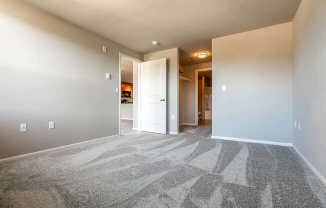 A hallway with a carpeted floor and white walls.