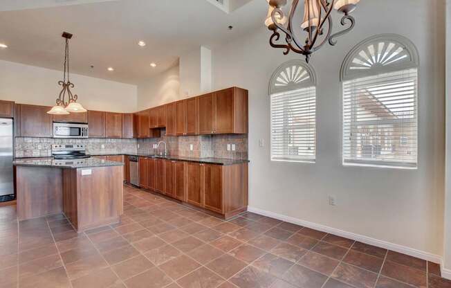 A kitchen with brown cabinets and a tile floor.