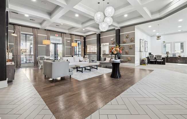A spacious living room with a wooden floor and white furniture.