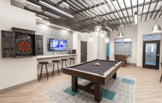 a games room with a pool table and a television at The Cosmopolitan, St Paul, MN, 55101