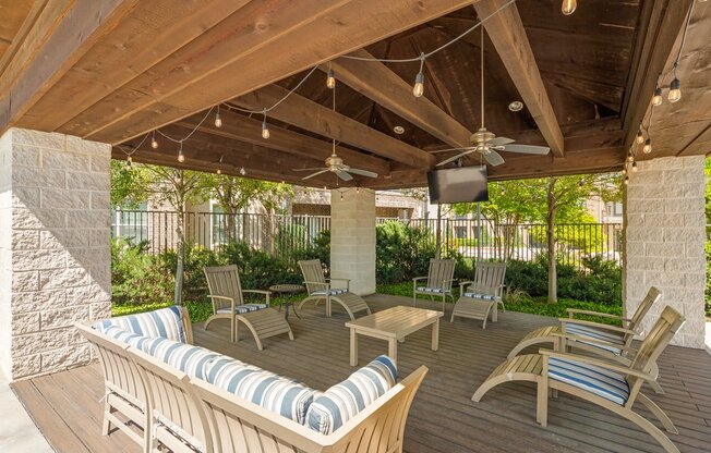 a covered patio with chairs and a tv