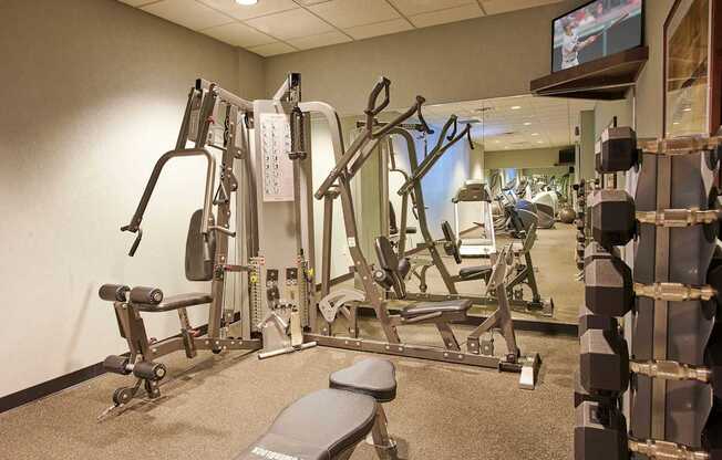 A gym with a variety of equipment including a flat screen TV.