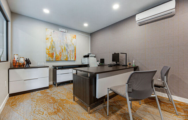 an office with two desks and two chairs and a painting on the wall at Citra Apartments LLC, San Diego, CA