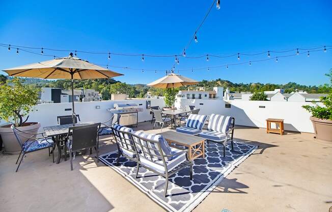 a patio with tables and chairs and umbrellas on a roof