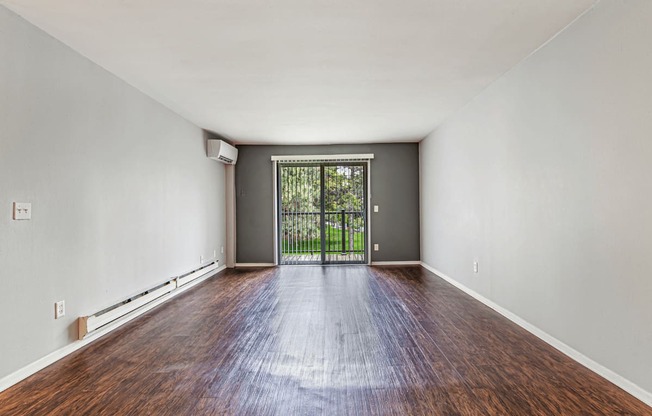 A room with a wooden floor and a sliding glass door.