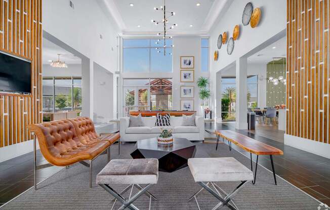 A modern living room with a brown leather sofa and a grey rug.