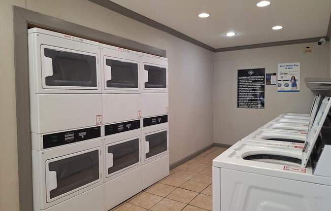 A row of white ovens are lined up in a room.