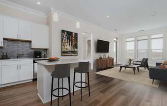 A modern kitchen with white cabinets and a wooden island.