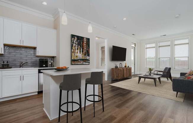 A modern kitchen with white cabinets and a wooden island.