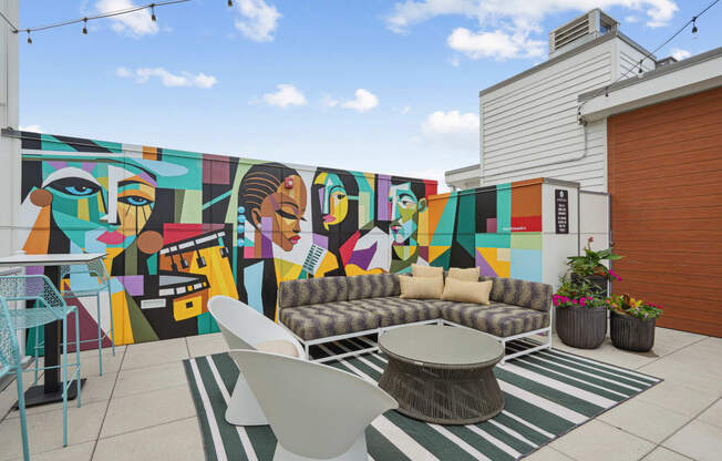 a mural on the side of a building with a couch and table