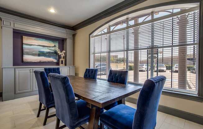 A dining room with a wooden table and blue chairs.