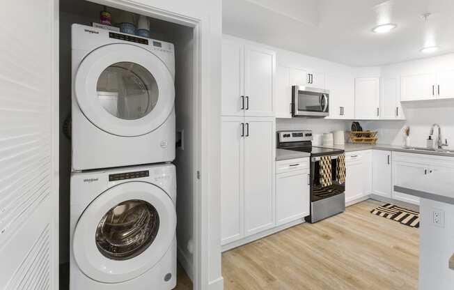 a white kitchen with a washing machine and a washer and dryer in it