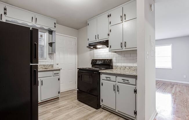 1295 west kitchen with white cabinets and black appliances
