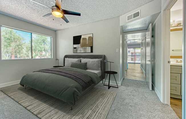 A bedroom with a bed and a ceiling fan.