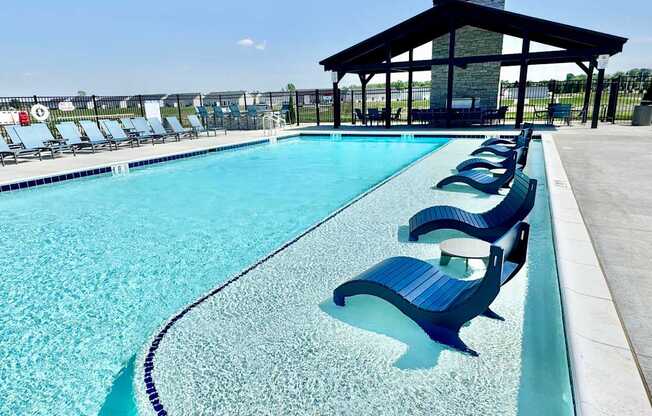 A pool with blue chairs and a black roof.