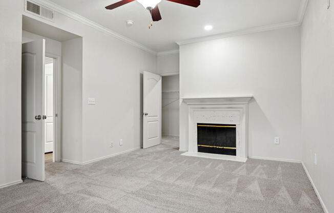 A room with a fireplace and a ceiling fan.