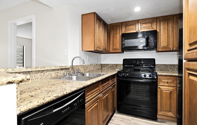 a kitchen with wooden cabinets and a black stove top oven