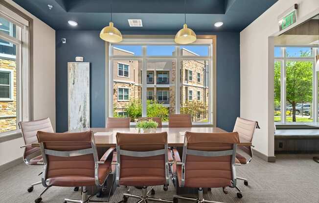 A conference room with a table and chairs and a view of a building outside the window.