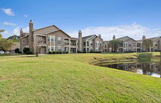 A row of houses with a pond in front.