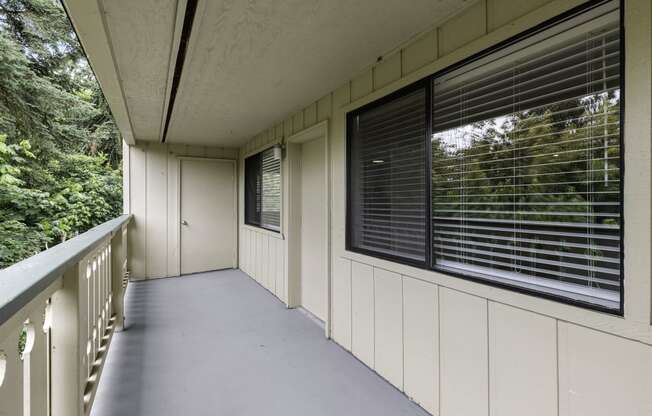 a large balcony with a view of the trees at Swiss Gables Apartment Homes, Kent, Washington 98032