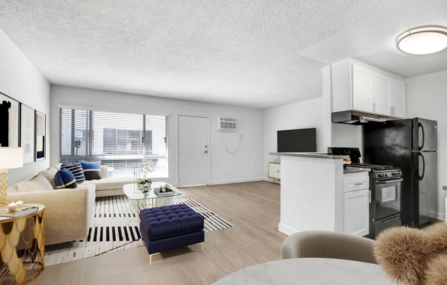 the living room of an apartment with a kitchen and a living room