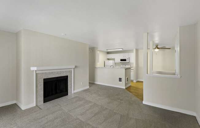 a living room with a fireplace and a kitchen in the background at Serra Vista Apartment Homes, Washington