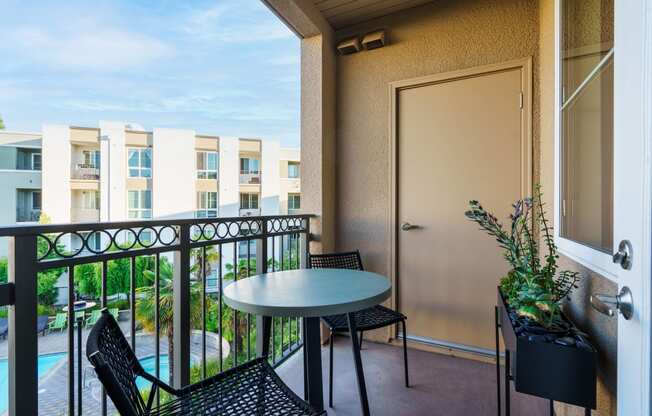 a balcony with a table and chairs and a door