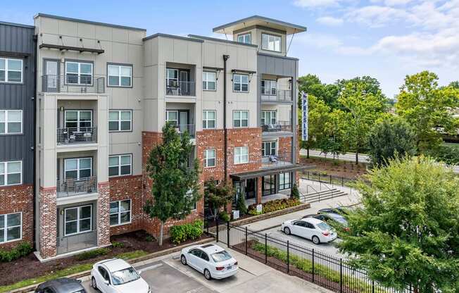 an aerial view of an apartment building with cars parked in front