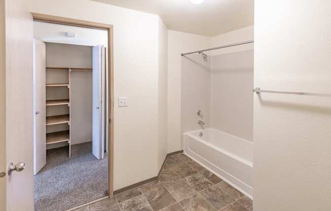 a bathroom with a bathtub and a closet