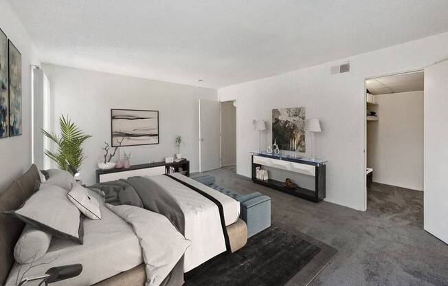 A bedroom with a bed, nightstand, and a plant.
