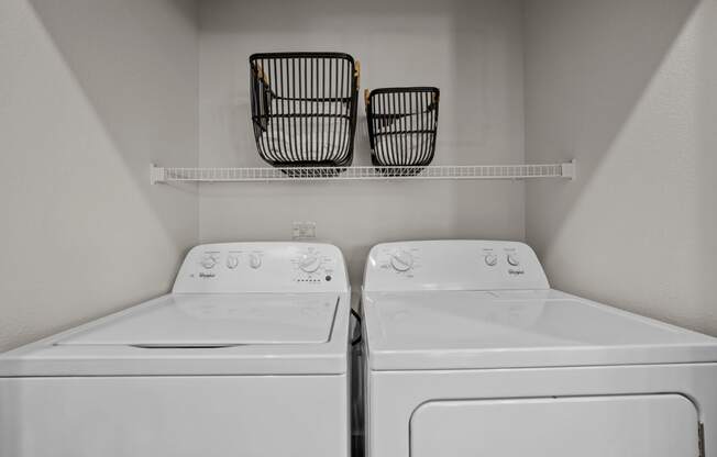 an empty laundry room with two washes and a dryer