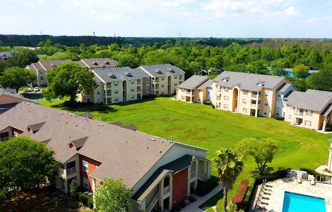 A bird's eye view of a residential area with houses and a swimming pool.