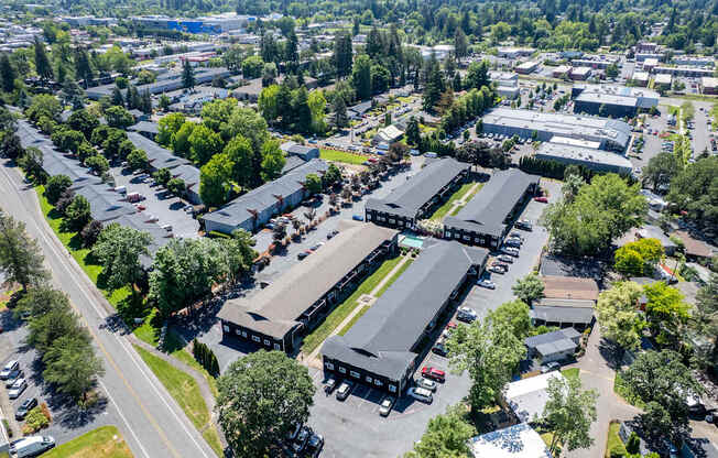 An aerial view of residential area with multiple buildings and parking lots.