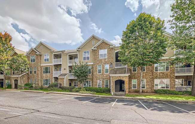 A large apartment complex with a parking lot in front.