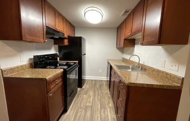 a kitchen with brown cabinets and a black stove top oven