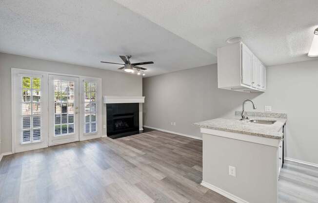 A kitchen with a fireplace and a fan on the ceiling.