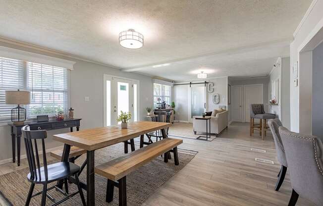 A dining room with a wooden table and chairs.