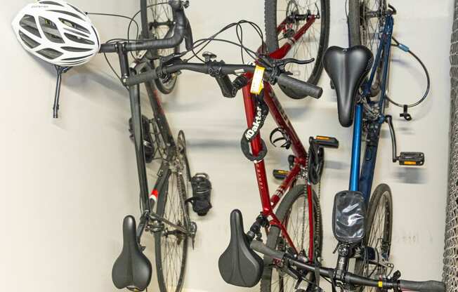 a bike rack in a garage with two bikes and helmets on it